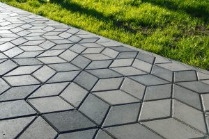 The footpath in the park is paved with diamond shaped concrete tiles.