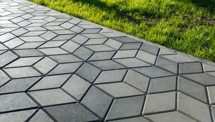 The footpath in the park is paved with diamond shaped concrete tiles.
