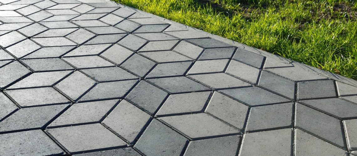 The footpath in the park is paved with diamond shaped concrete tiles.