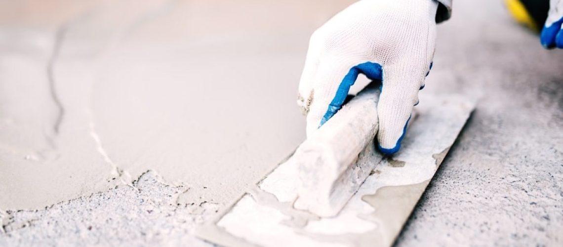 industrial worker on construction site laying sealant for waterproofing cement